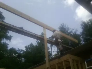 Carpenter setting a ridge beam over a new addition frame — Ice Dam Removal by Roofing Brothers in Carolina Beach