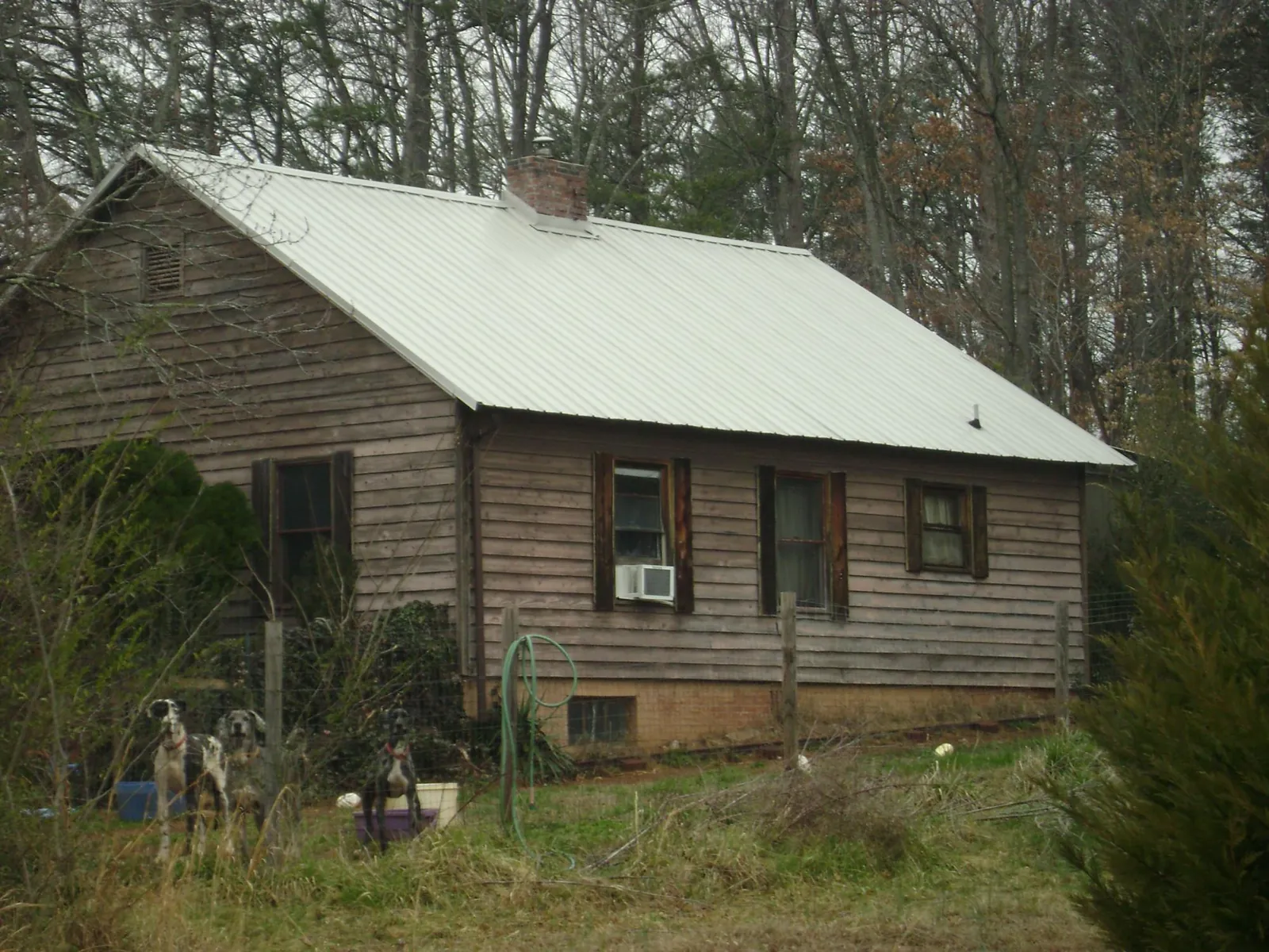 White metal roof on an old wood sided farmhouse, from a Metal Roof Installation job in Carolina Beach